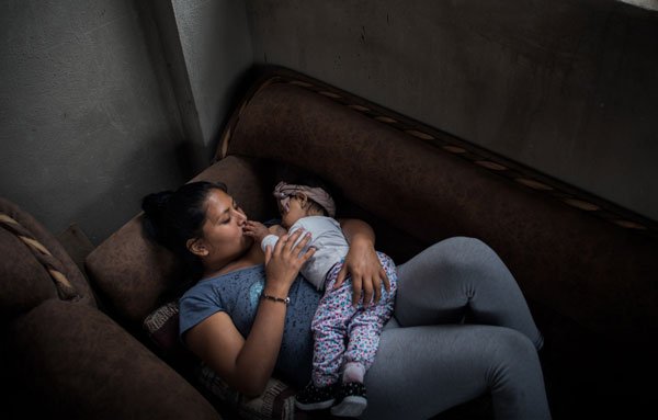 Familias tras las rejas. Las víctimas colaterales de un sistema fallido. 3 Eli alimenta a su hija de un año en su hogar; ella al igual que muchas mujeres tras la detención de sus esposos han quedado responsables de la mantención de su familia. Hermanas, esposas y madres de los privados de libertad asumen el liderazgo de su hogar, multiplican sus esfuerzos de trabajo y tiempo para las visitas y demandas económicas de su familia dentro y fuera de prisión.