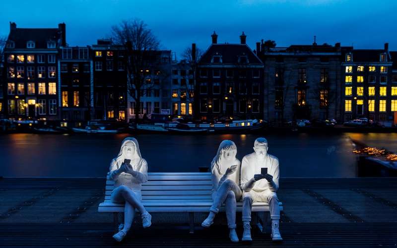 Una escultura sobre la adicción a los smartphones 1 absorbed by light uno escultura adicción